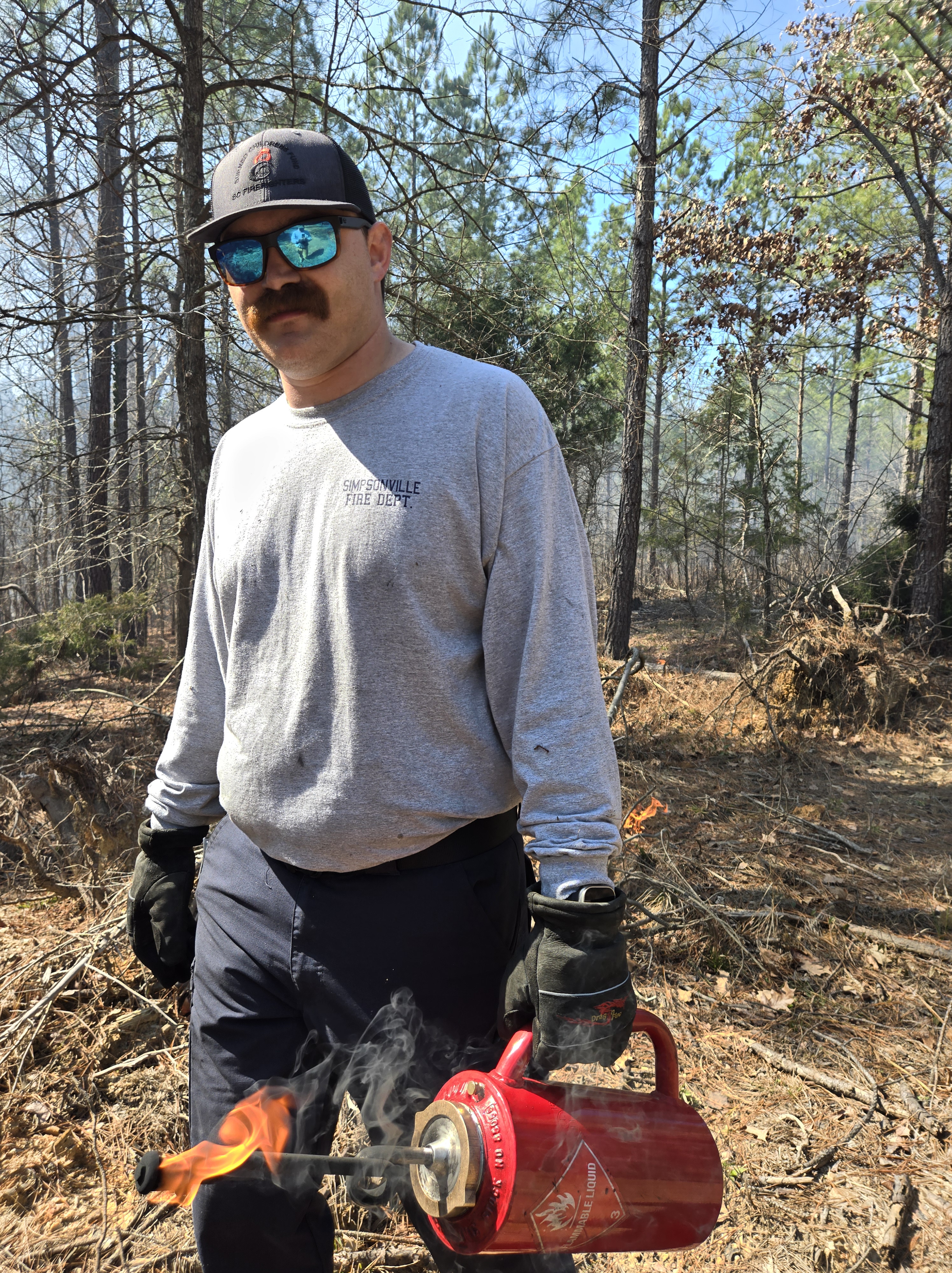 Three accompaniments of an outdoor fire. The pieces of wood appear part-cylinder in cross-section and are scored in lines ...